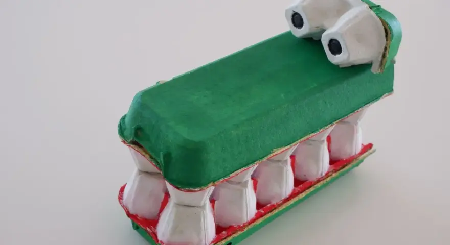 Un crocodile rigolo, fruit d'un bricolage avec des boîtes d'œufs. Ses dents blanches et sa gueule rouge font un effet saisissant.