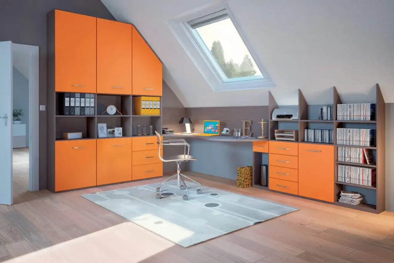 Bureau sous pente lumineux avec rangements orange vifs, un bureau fonctionnel et une fenêtre de toit offrant une vue sur les arbres.