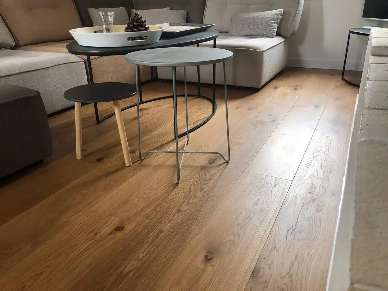 Un salon moderne avec un parquet en bois clair. Ce sol chaleureux est idéal pour répondre à la question : quel parquet choisir pour un intérieur cosy ?