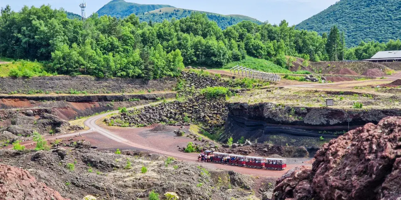 Petit train touristique traversant le volcan de Lempt&eacute;gy, un site naturel impressionnant. Avis positifs pour cette visite.