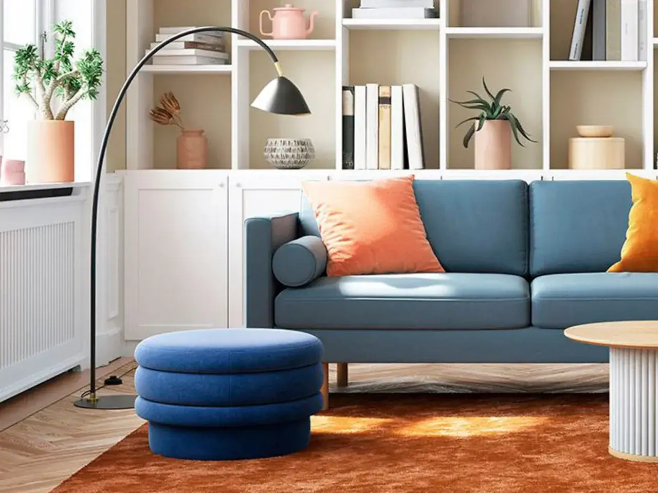 Canapé bleu profond, pouf assorti et coussins orange vif créent un contraste saisissant, la couleur complémentaire bleu est mise en valeur.