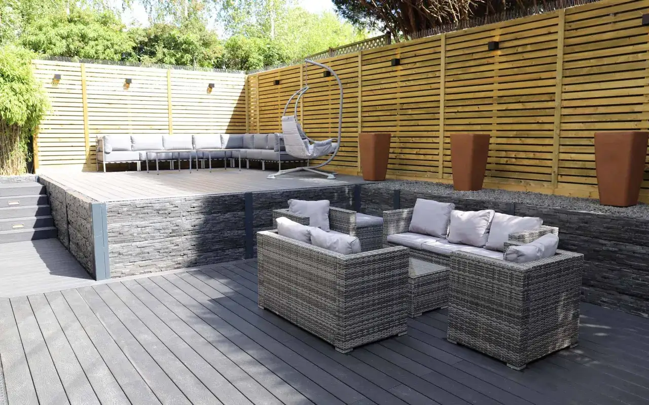 Aménagement terrasse en bois moderne avec salon de jardin, fauteuil suspendu et jardinières. Un espace extérieur invitant à la détente.