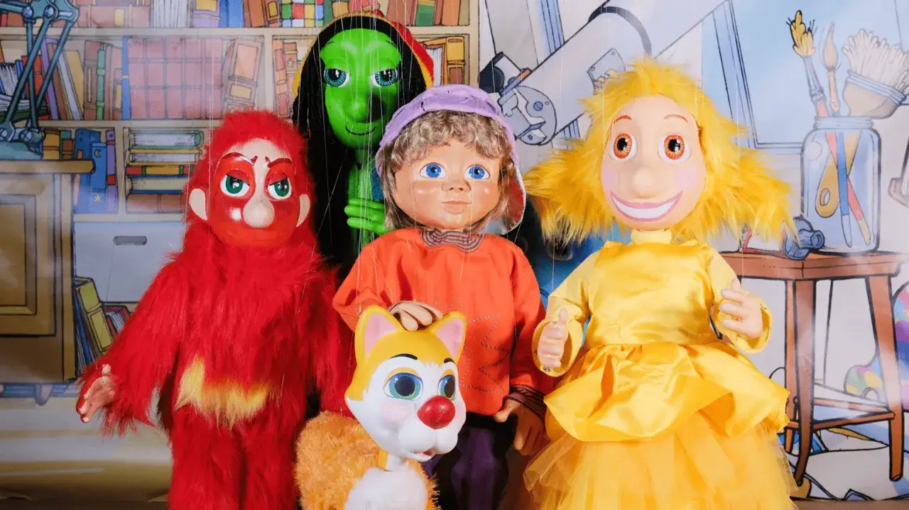 Marionnettes colorées pour un spectacle enfant 2 ans : un monstre rouge, une extraterrestre verte, un garçon, un chat et une fille en jaune.