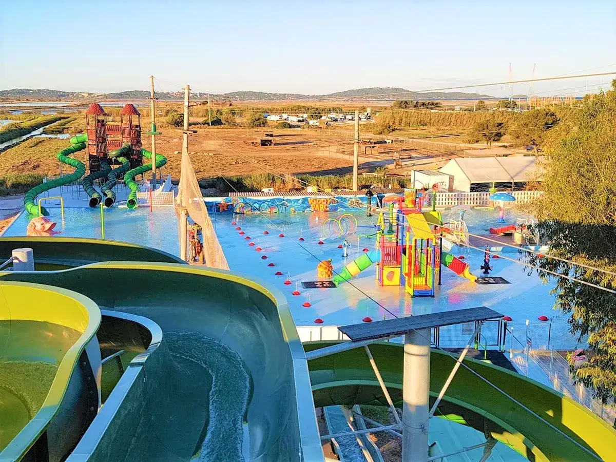 Vaste aire de jeux aquatiques avec toboggans verts et structures color&eacute;es, un paradis pour s'amuser dans ce parc aquatique du sud de la France.