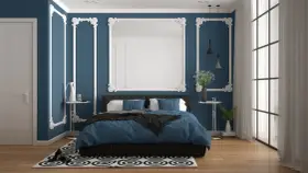 Chambre élégante avec murs bleu nuit et moulures blanches. Le lit est paré de linge de lit bleu roi, créant 2 couleurs qui vont bien ensemble pour une chambre.