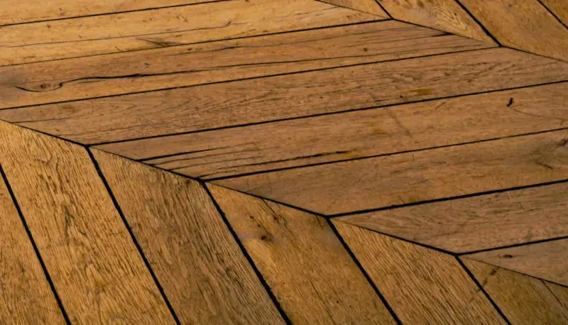 Parquet en bois vieilli, pose en chevrons. Un style intemporel pour savoir quel parquet choisir.
