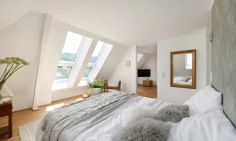 Douillette chambre mansardée avec lits douillets, fenêtres de toit lumineuses et vue sur la verdure. Un coin paisible pour se détendre.