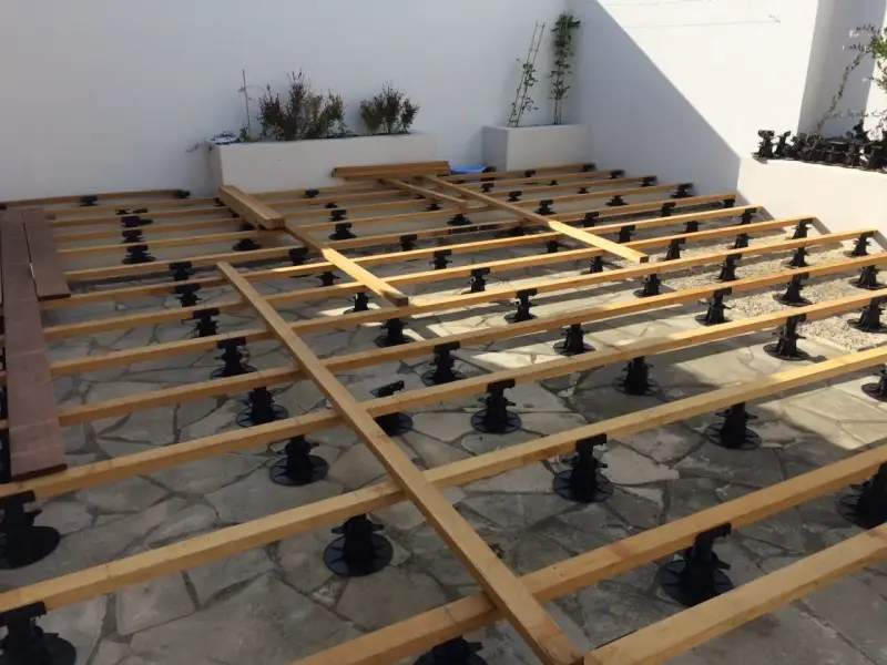 Structure en bois pour un aménagement terrasse en bois, sur des plots réglables. Les lames de bois sont prêtes à être posées.